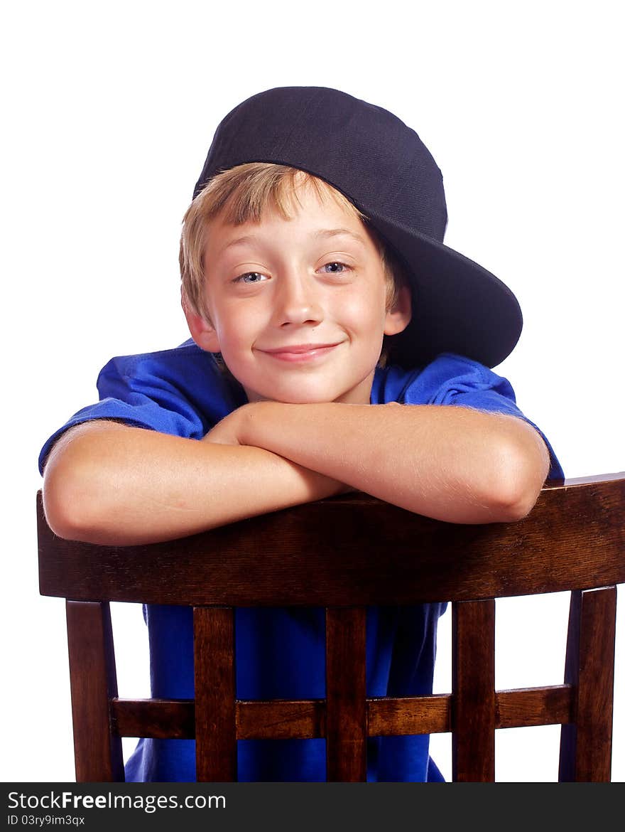 Young boy leaning on a chair with a smirk on his face. Young boy leaning on a chair with a smirk on his face