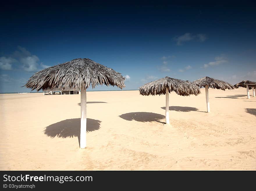 Umbrella in desert under blue sky