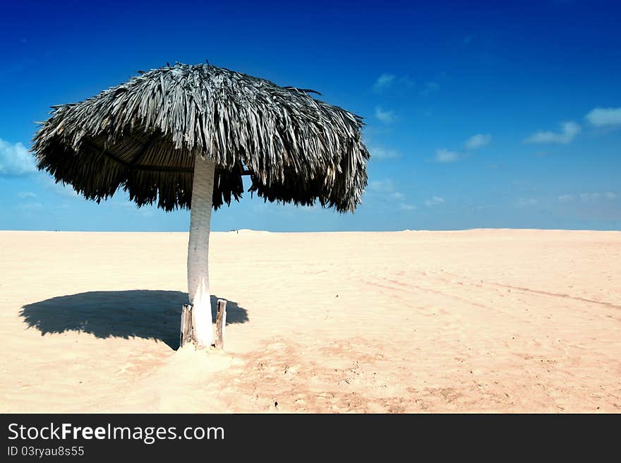 Umbrella in desert under blue sky