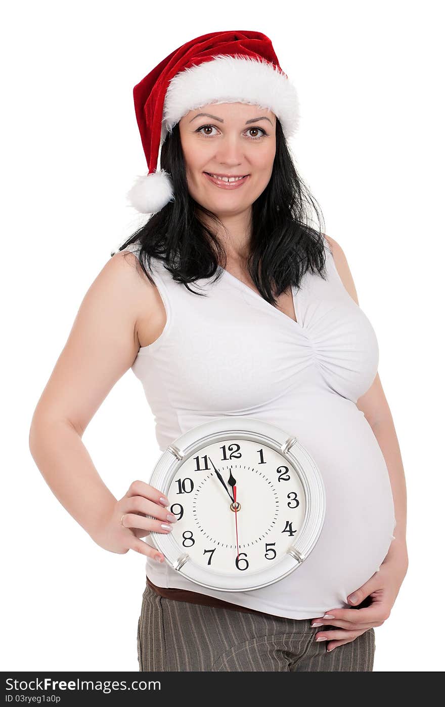 Portrait of a pregnant woman in santa hat with clock over white background. Third trimester. Portrait of a pregnant woman in santa hat with clock over white background. Third trimester.