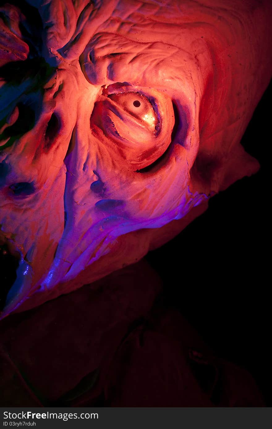 Close Up of a Scary ghoul in haunted house with colored light. Close Up of a Scary ghoul in haunted house with colored light