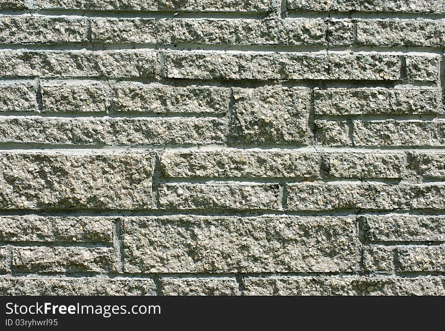 Exterior cement stone wall in sunshine, part of chimney