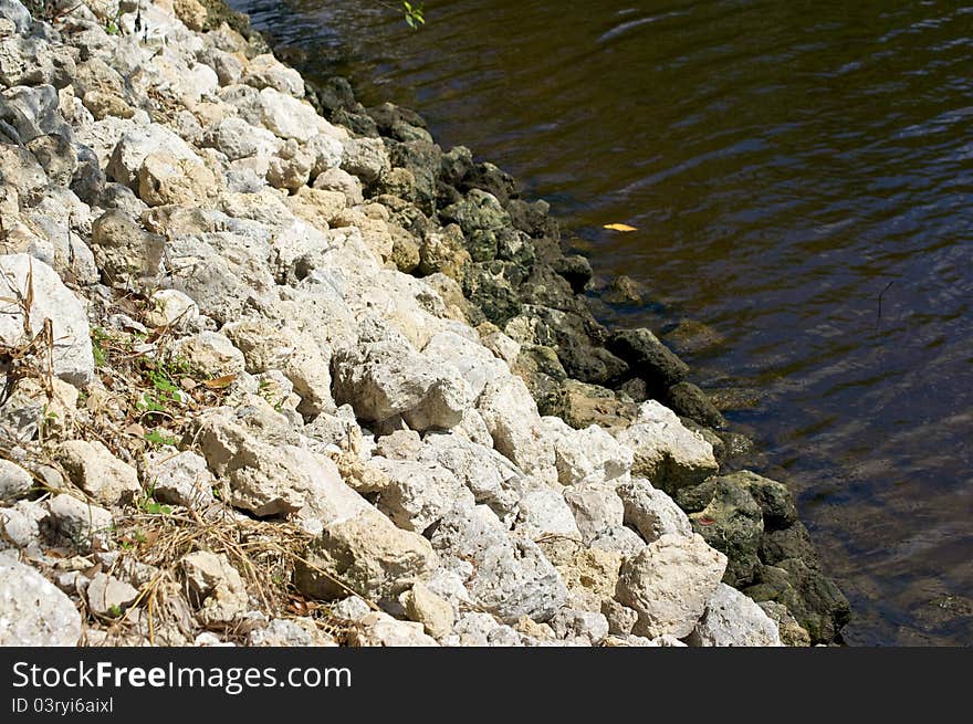 Looking down stone embankment to water below. Looking down stone embankment to water below.