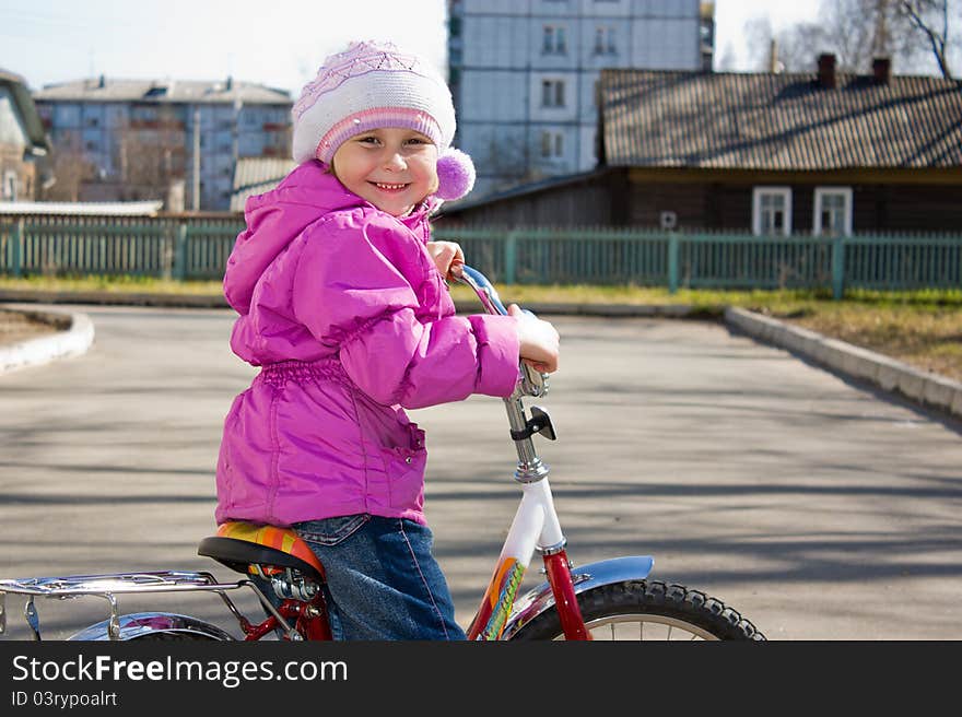 A girl riding a bicycle in the yard. A girl riding a bicycle in the yard.