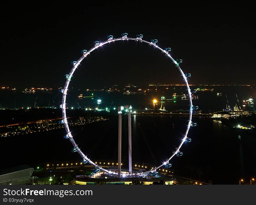 Singapore Flyer – the 165-m high Ferris wheel magnificently lit in the night.