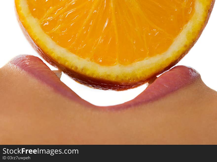 Profile of open female mouth with orange slice over white background