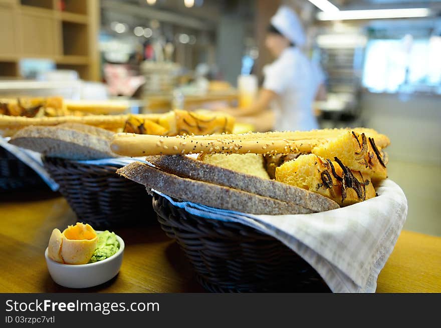 Bread basket against the background of a restaurant kitchen. Bread basket against the background of a restaurant kitchen.