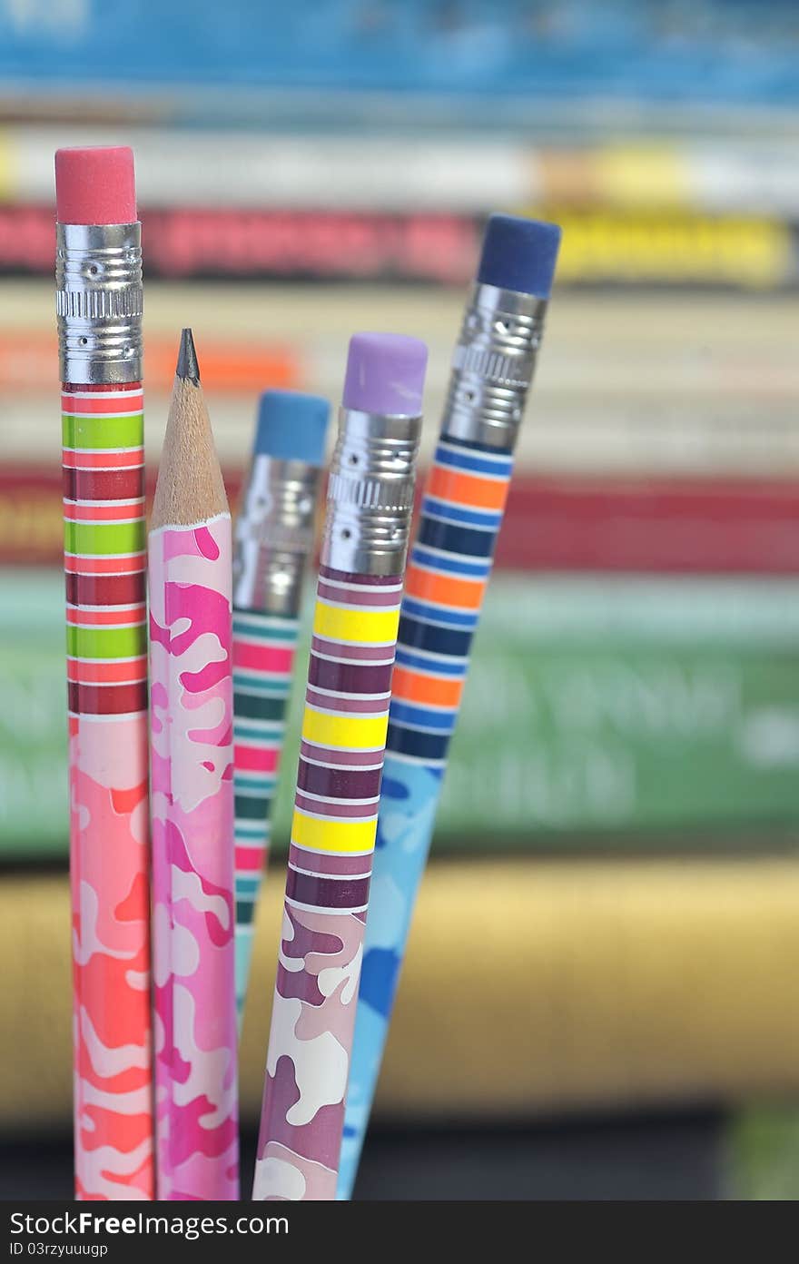 Closeup of colored pencils with books in background