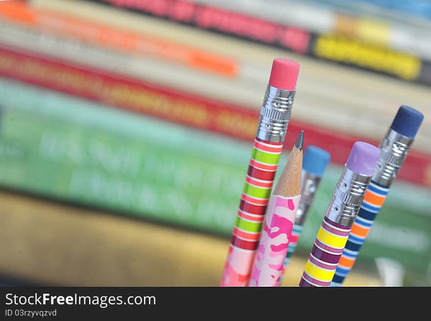 Closeup of colored pencils with books in background