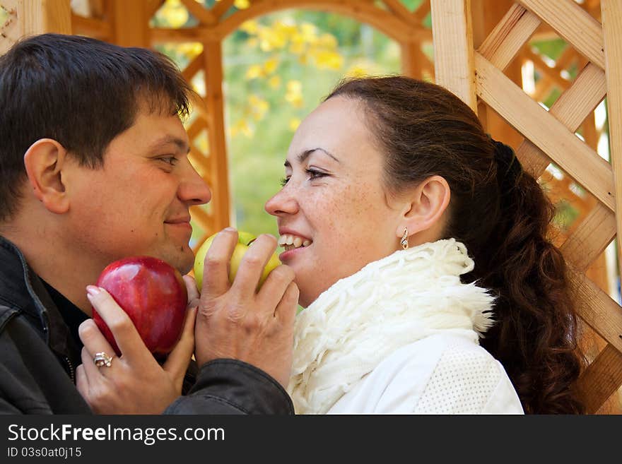 Young happy couple eating apples