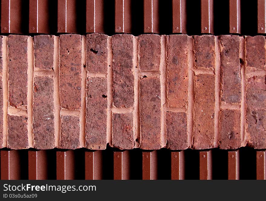 Closeup of a red brick surface with metal around it. Closeup of a red brick surface with metal around it