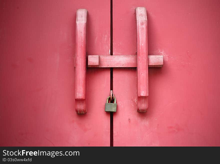 Old red wooden door handle is closed