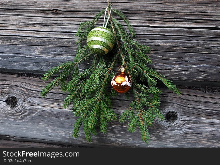 Christmas tree twig and decorations against the background of the shabby wooden wall