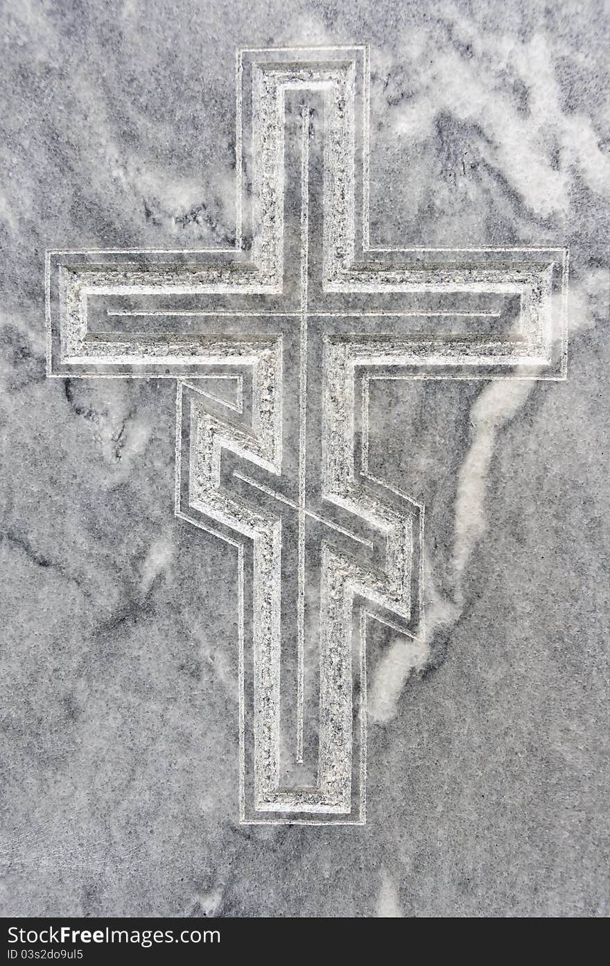 Closeup of orthodox cross carved in gravestone