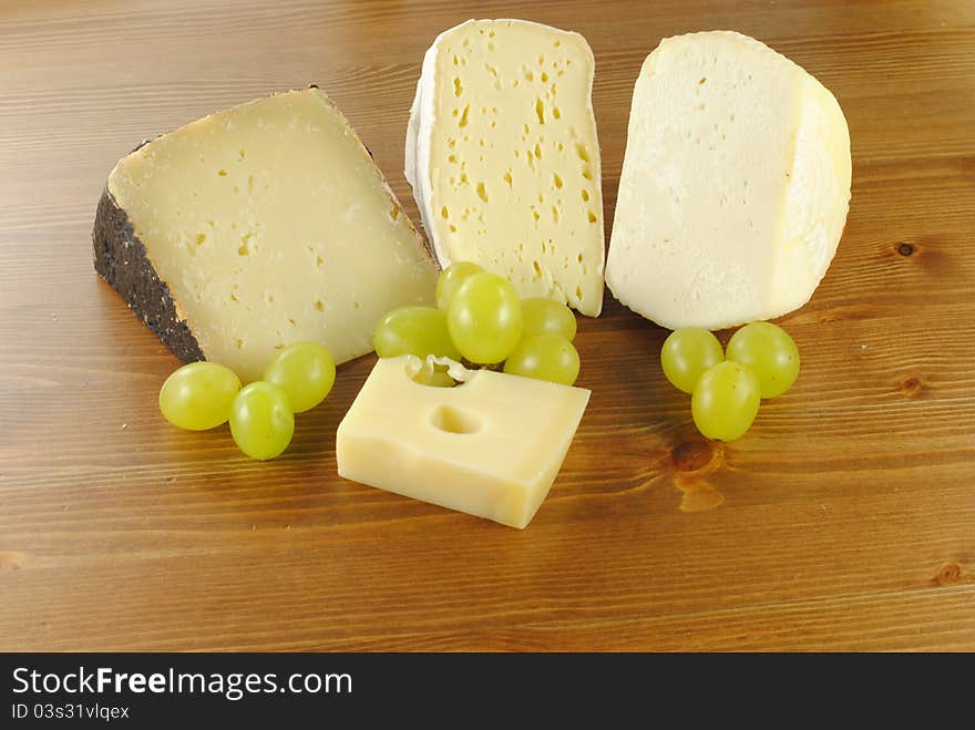 Italian cheese with grapes on wooden table