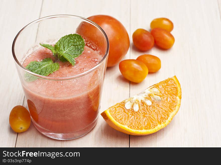 Tomatoes and orange juice on table