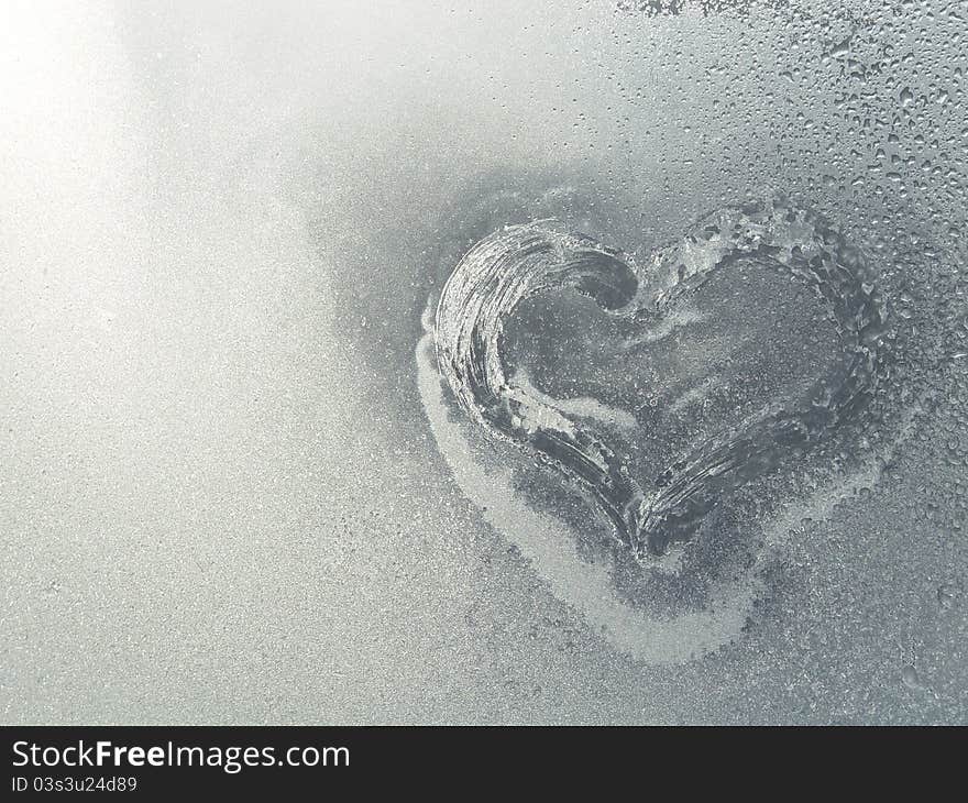 Frozen heart in the frosty window