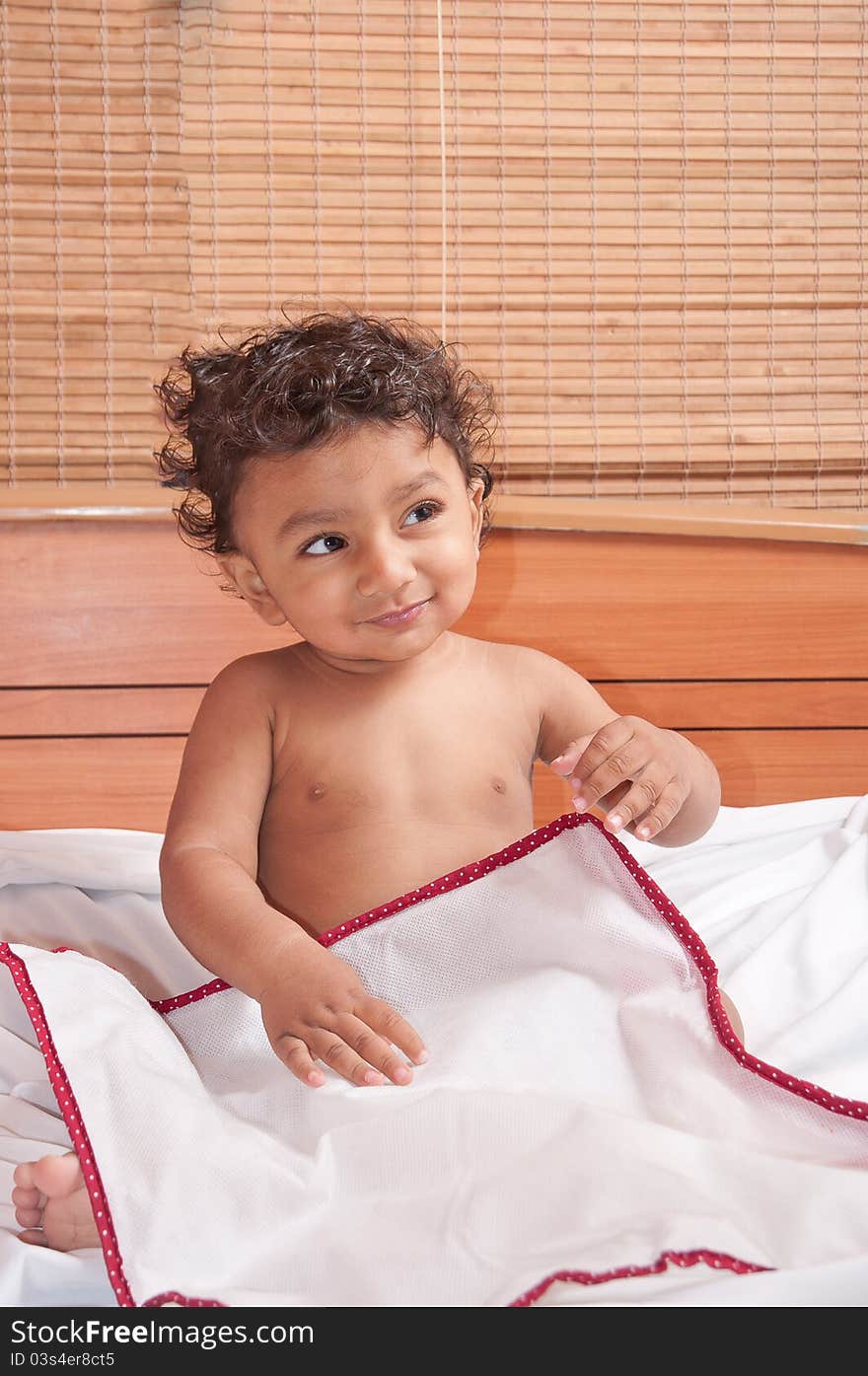 Happy smiling toddler pre school boy playing bed