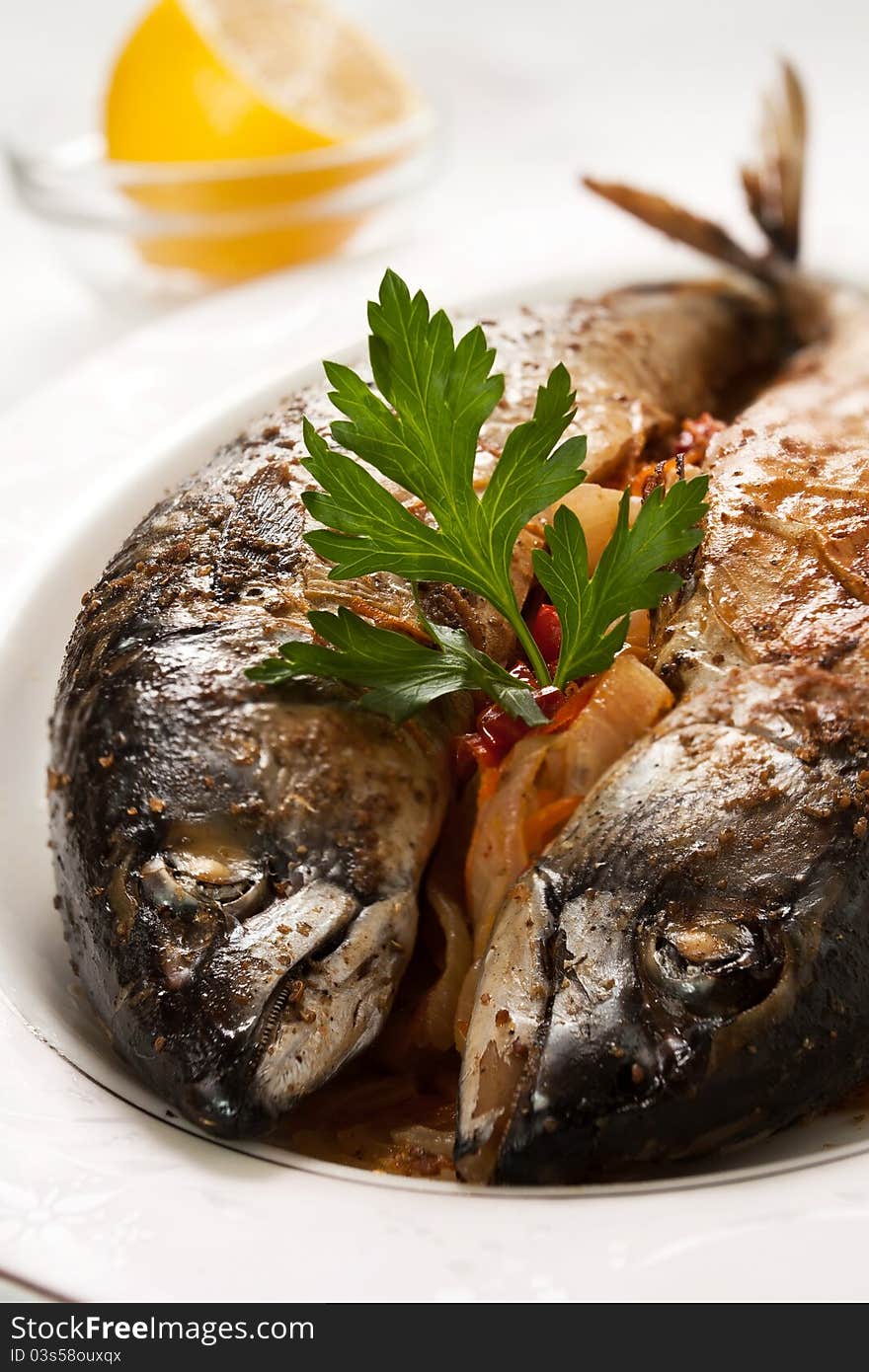 Two cooked mackerels on a plate. Two cooked mackerels on a plate