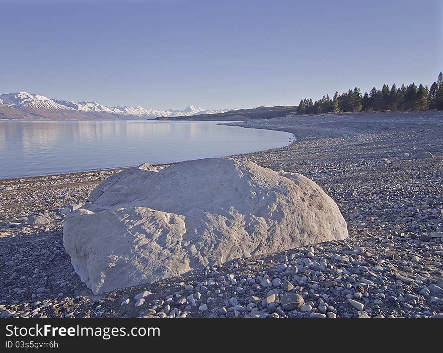 Boulder on the shore of Lake Pukaki with Mount Cook in the background. Boulder on the shore of Lake Pukaki with Mount Cook in the background