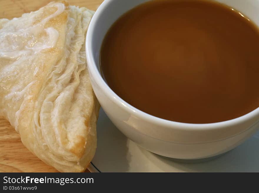 Coffee with cream and a turnover