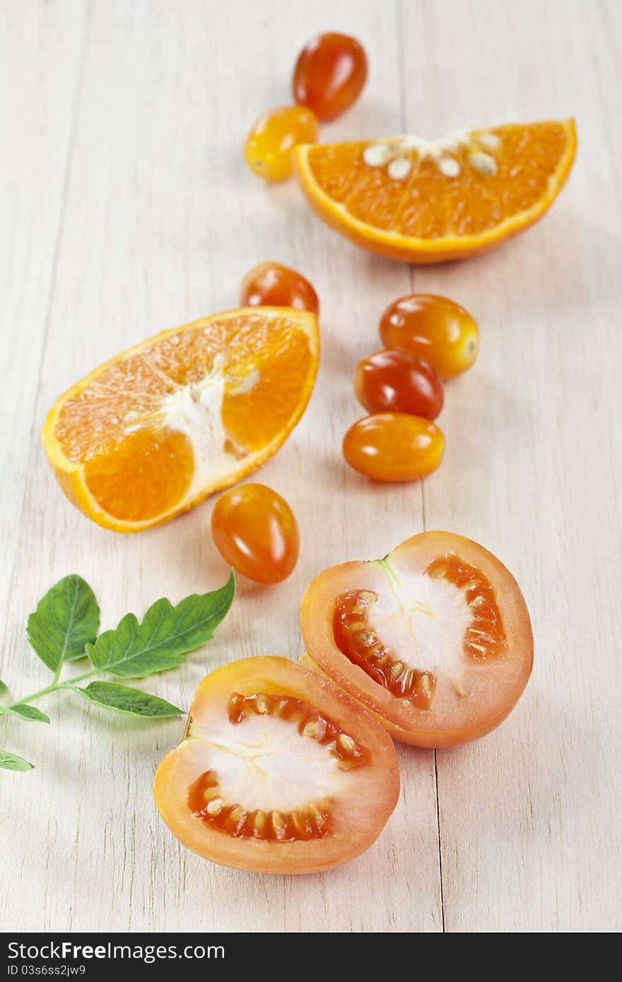 Tomato vegetable with orange fruit on table