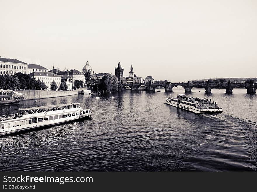 A photo showing two boats on the Vltava river through Prague, the capital of the Czech Republic. The bridge across the river is the famous Charles Bridge. A photo showing two boats on the Vltava river through Prague, the capital of the Czech Republic. The bridge across the river is the famous Charles Bridge