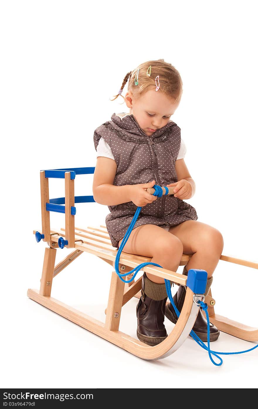 Little girl sitting on sledge in studio on white background. Little girl sitting on sledge in studio on white background