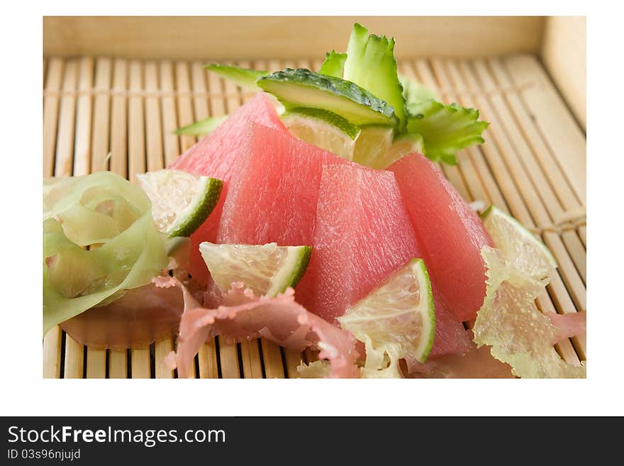 Raw tuna decorated with cucumber and lime