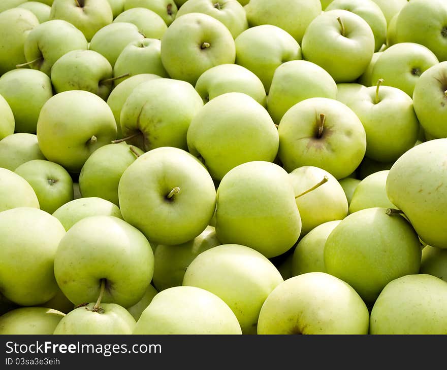 Green apples pile closeup background. Green apples pile closeup background.