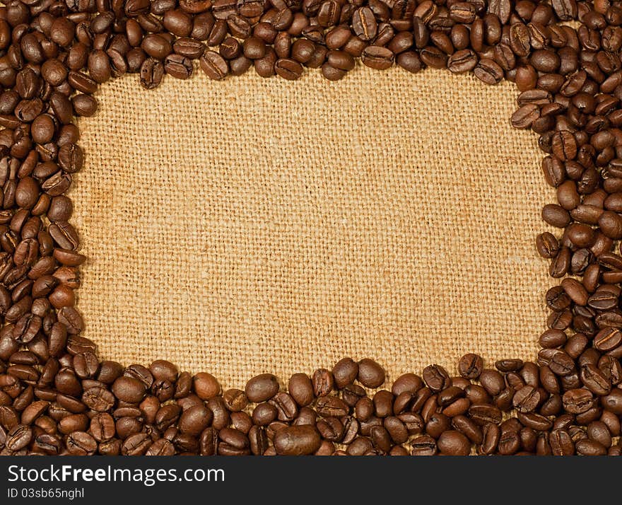 Coffee beans on a burlap texture background