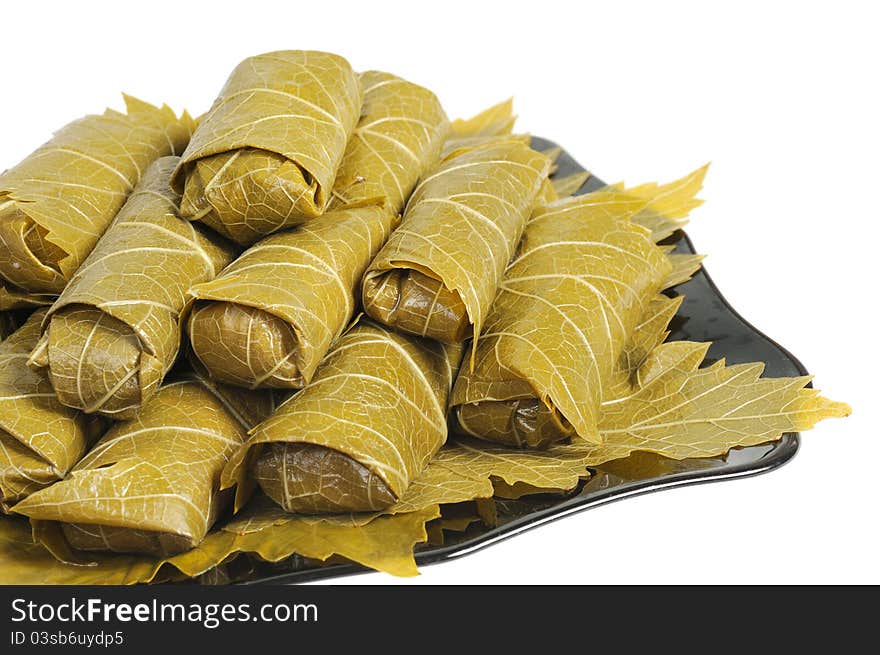 Dolma on a black plate. Isolated on white background. Dolma on a black plate. Isolated on white background.