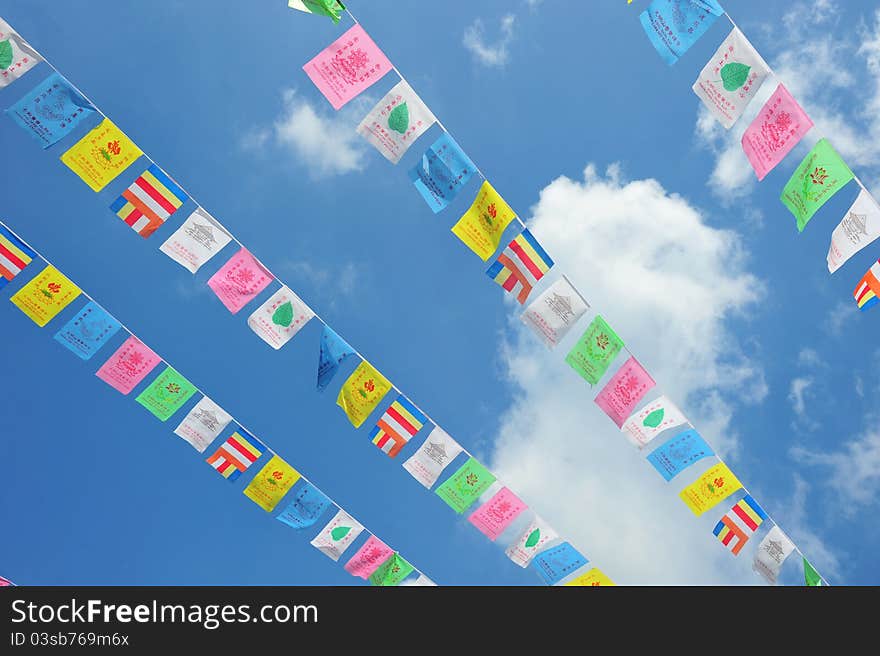 String Of Flags At A Religious Celebration Against Blue Sky. String Of Flags At A Religious Celebration Against Blue Sky