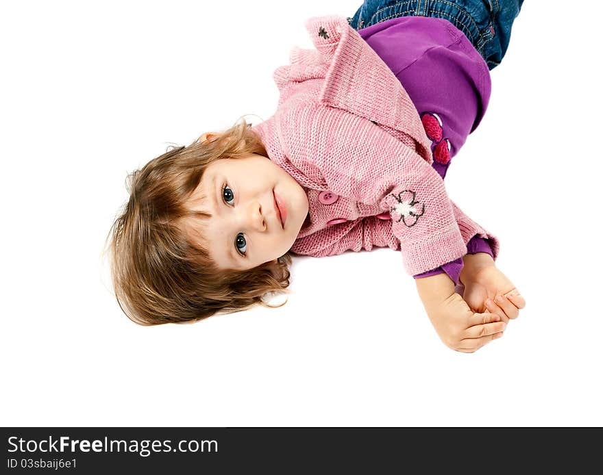 Little girl lying on white floor in the studio