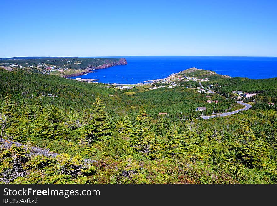 Mountain top view of the coastal town of Flatrock in the province of Newfoundland in Canada. Surrounded by majestic landscape and seascape it is also one of the most visited areas on the East Coast Trail System by tourists. Mountain top view of the coastal town of Flatrock in the province of Newfoundland in Canada. Surrounded by majestic landscape and seascape it is also one of the most visited areas on the East Coast Trail System by tourists.