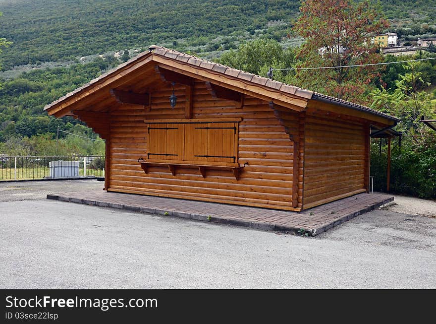 Wooden cottage in parking place near the highway