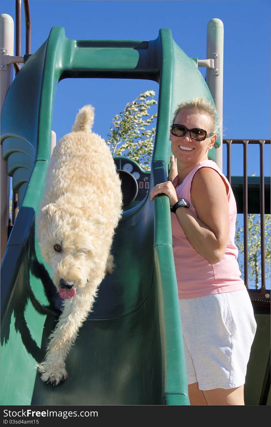 Woman is watching her dog on slide