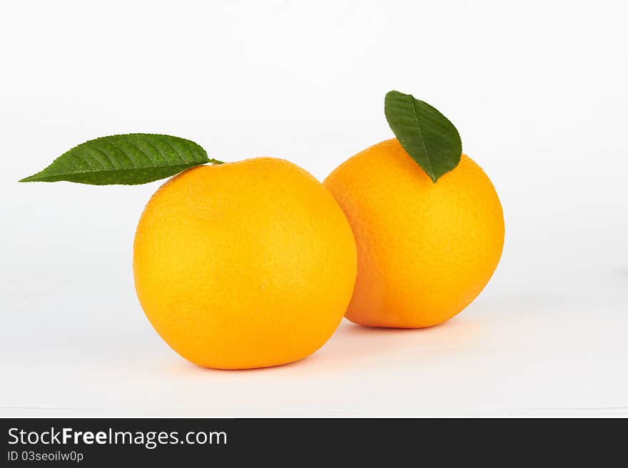 Ripe oranges with leaf on white