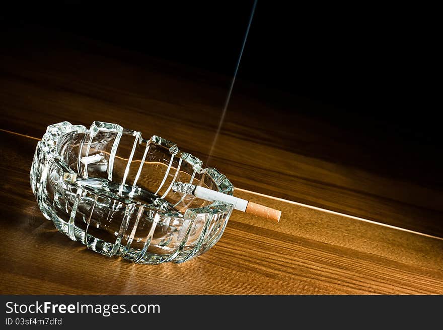 Cigarette and ashtray on wood,grunge background. Cigarette and ashtray on wood,grunge background