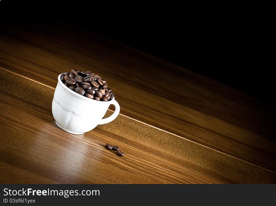 Cup of coffee on wood and black background. Cup of coffee on wood and black background