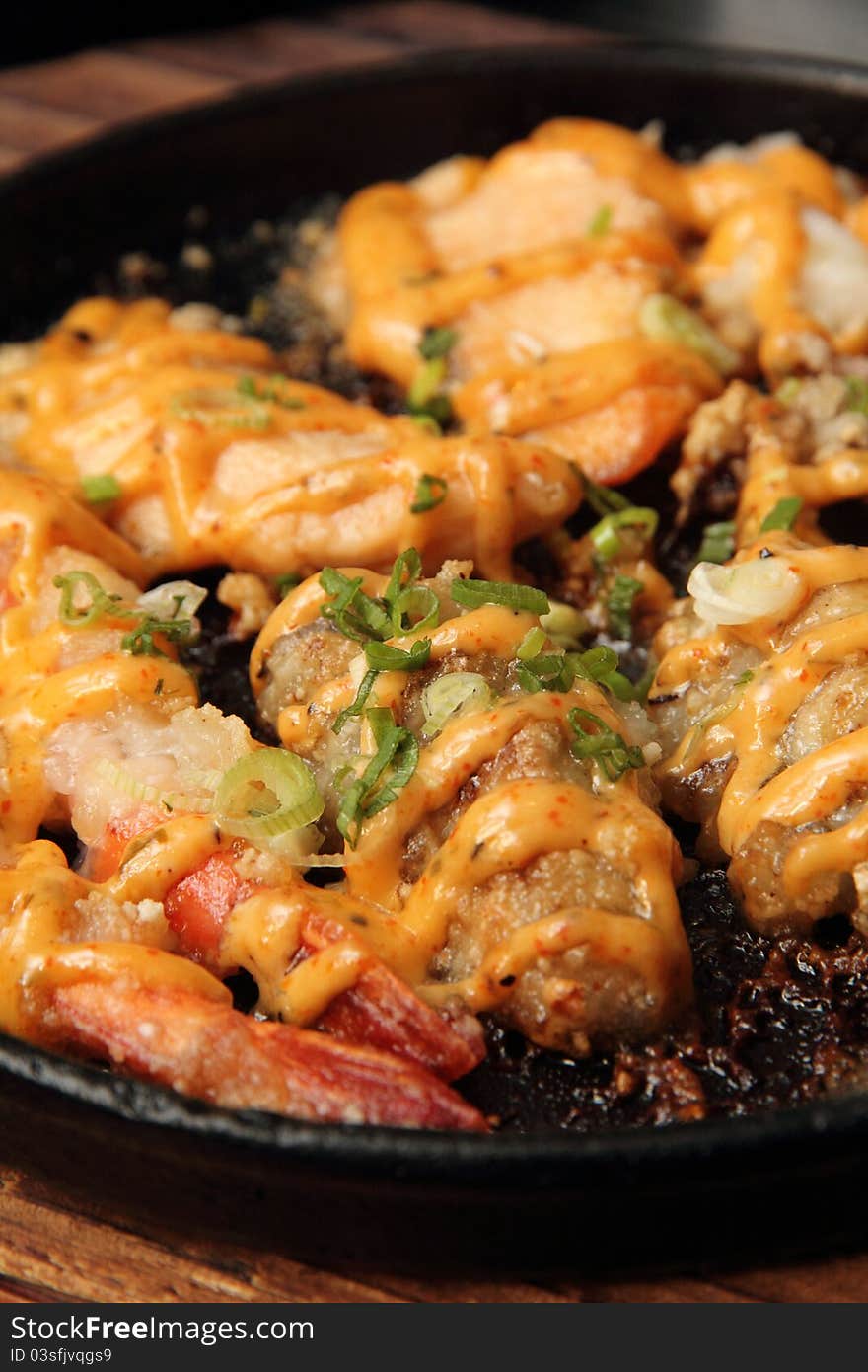 Asian Grilled Seafood Platter served on black steel pan and wooden block