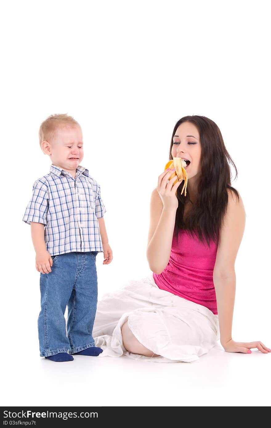 Child crying mother eat banana over white background