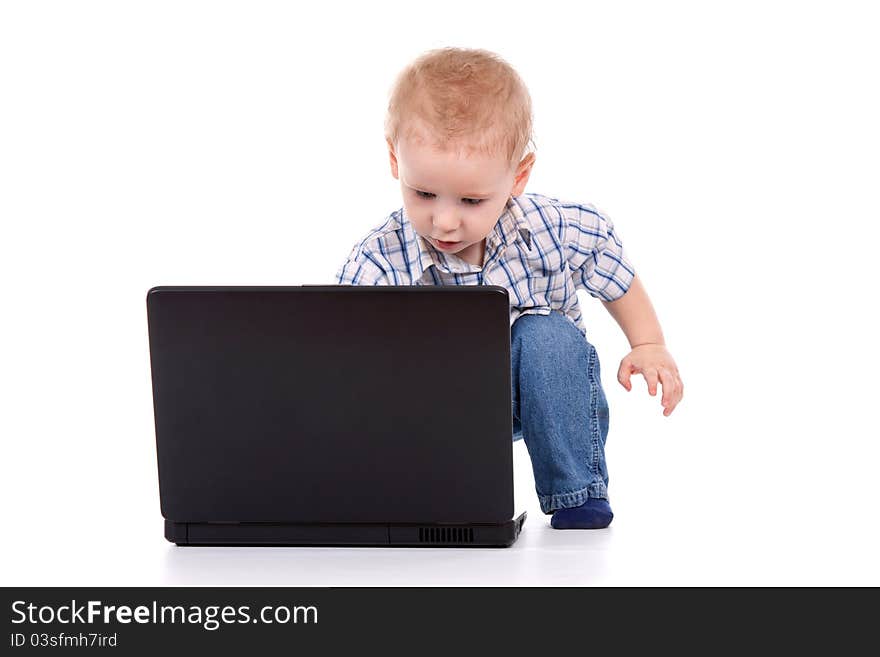 Little boy sitting with laptop over white background