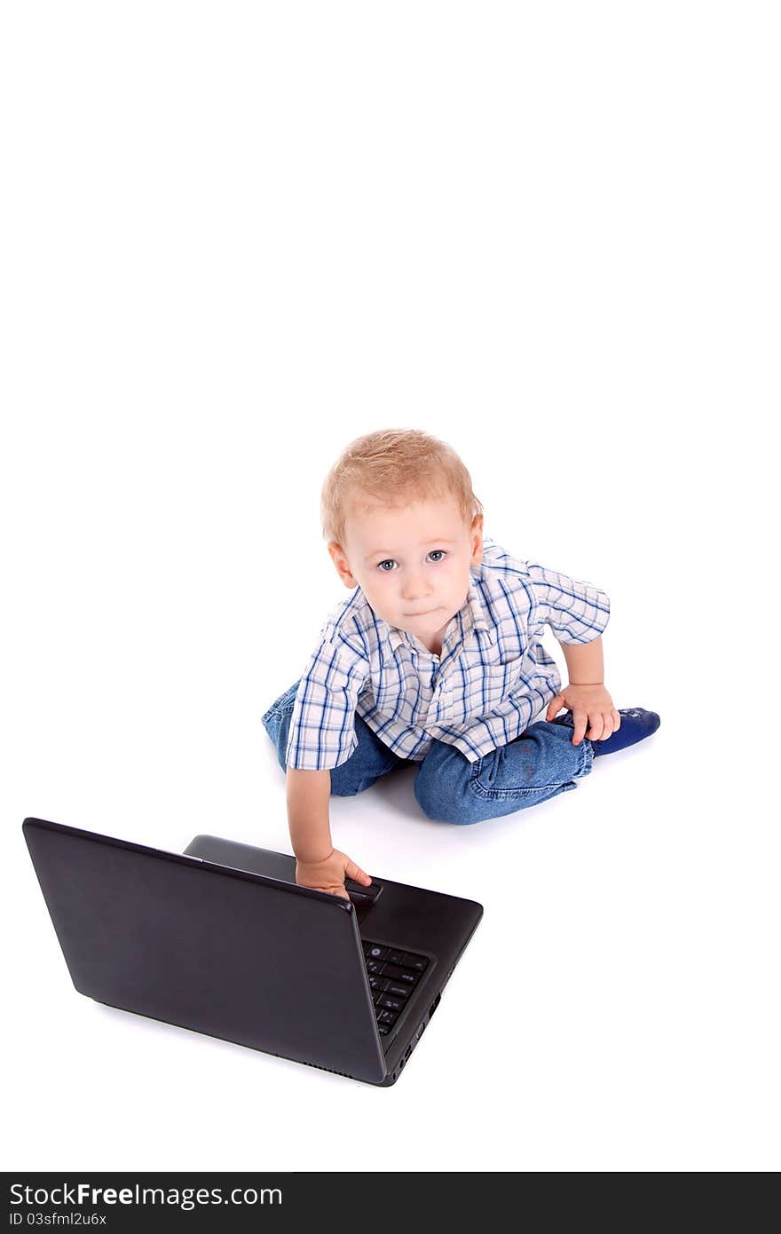 Little boy sitting with laptop over white background