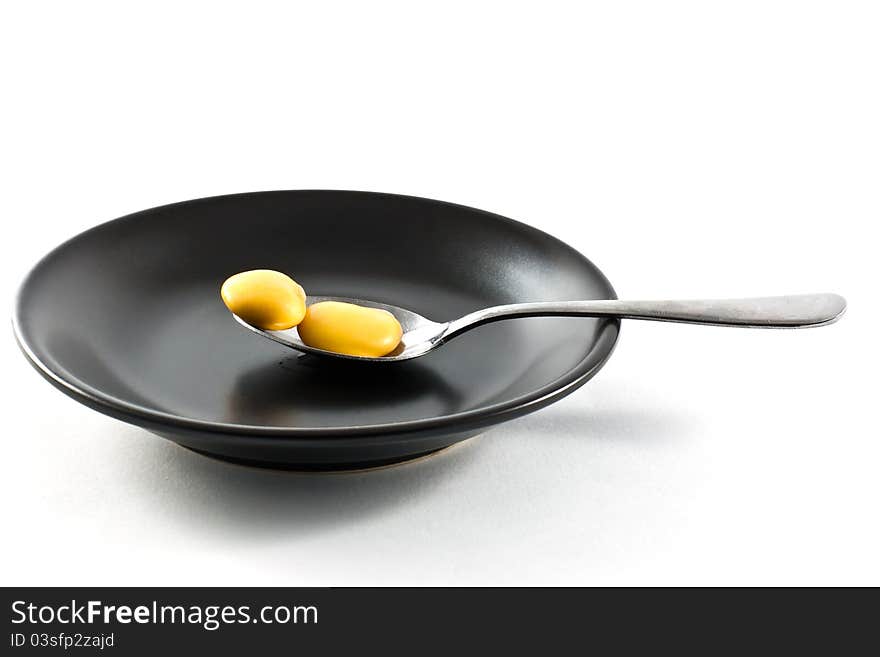 Two lupins on a spoon resting on a black plate. Two lupins on a spoon resting on a black plate