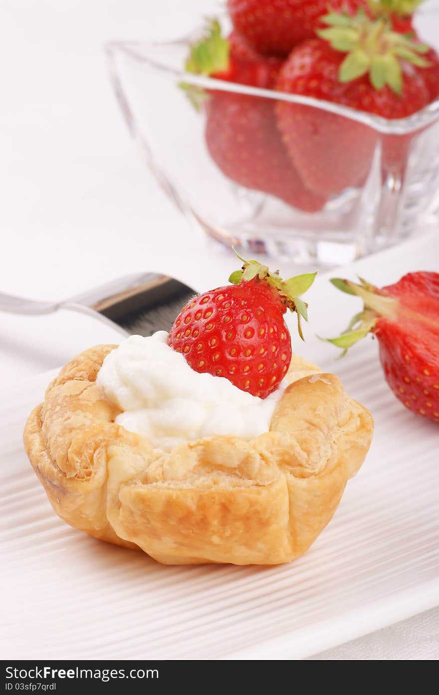 Small strawberry tart on a white plate. Selective focus, ultra-shallow DOF