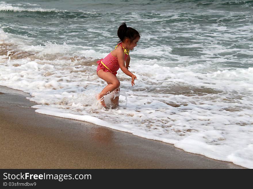 Cute little girl playing on the beach