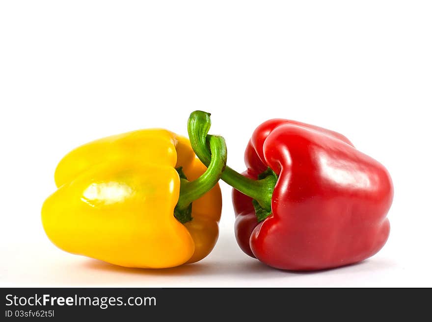 Two red and yellow peppers together. Two red and yellow peppers together