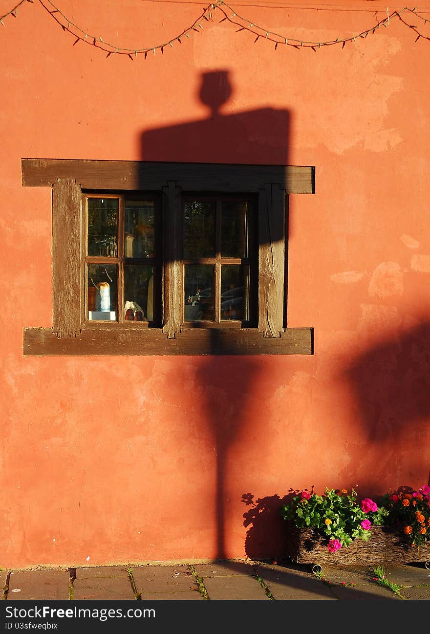 Window in historic old home in Kaunas Old Town, Lithuania with  planter box & road sign shadow . Window in historic old home in Kaunas Old Town, Lithuania with  planter box & road sign shadow .