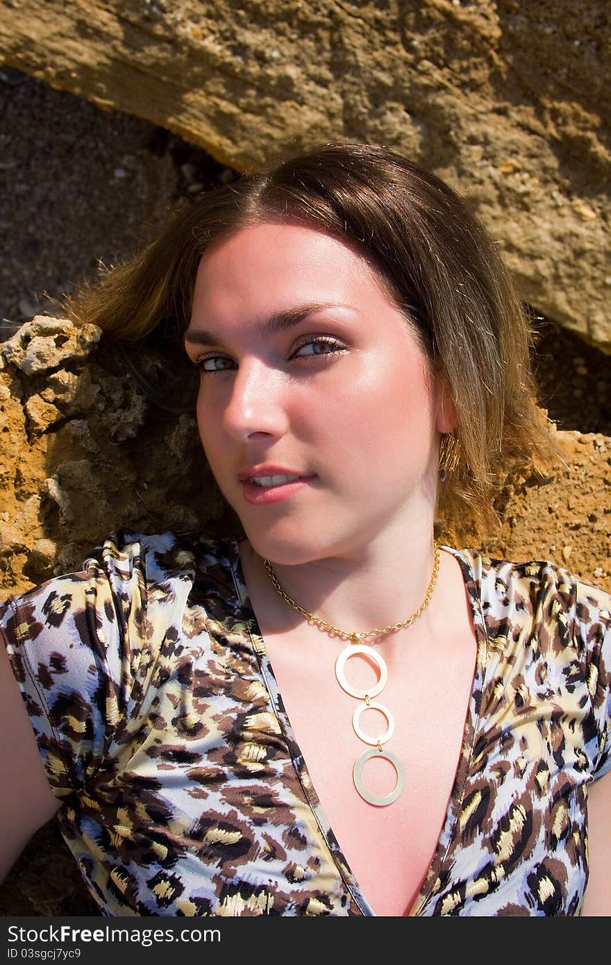 Beautiful woman on stone beach resting